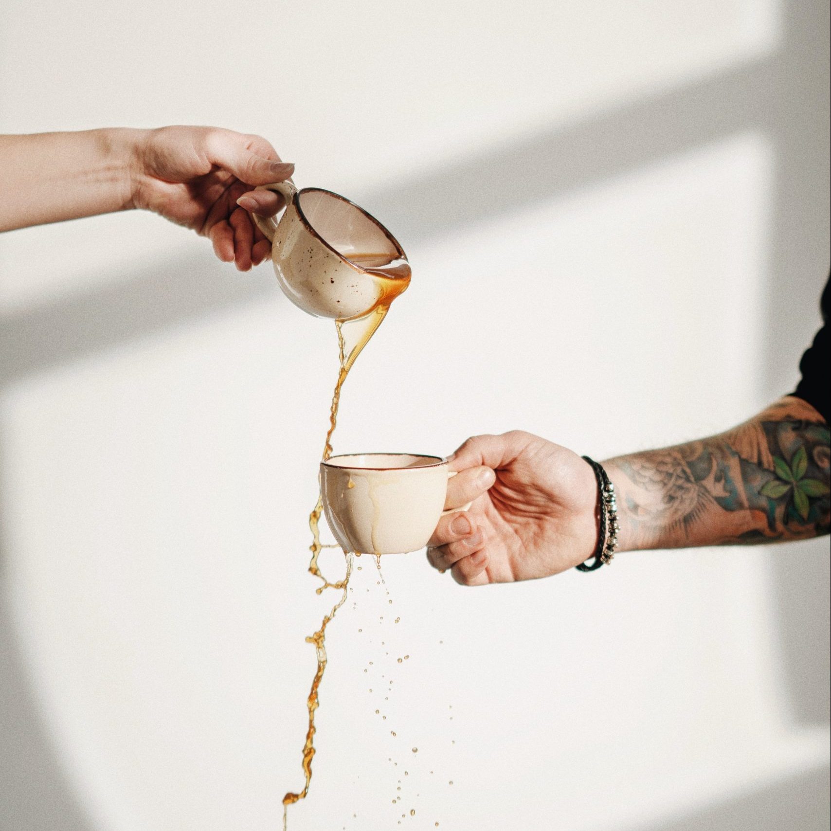 Coffee being poured into another cup